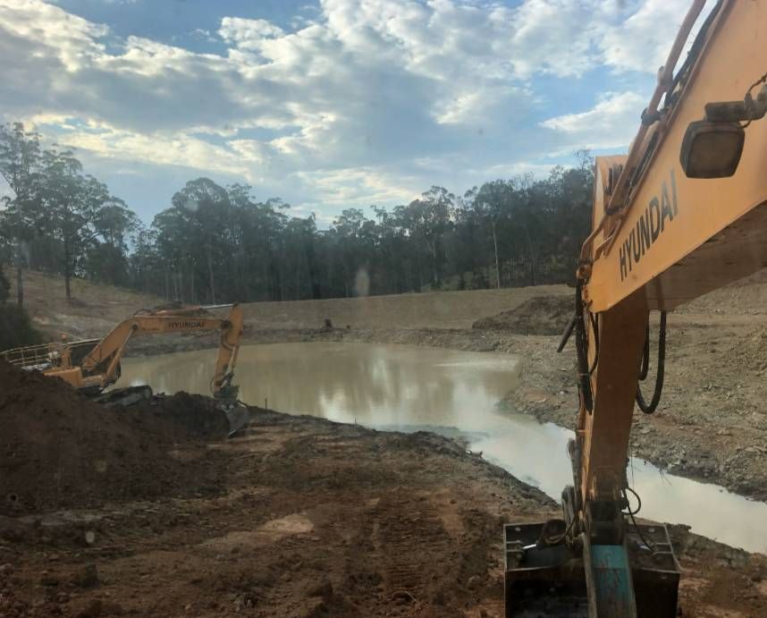 A Large Trail Of Water With A Digger Arm To The Right — A2Z Property Services In Kybong, QLD