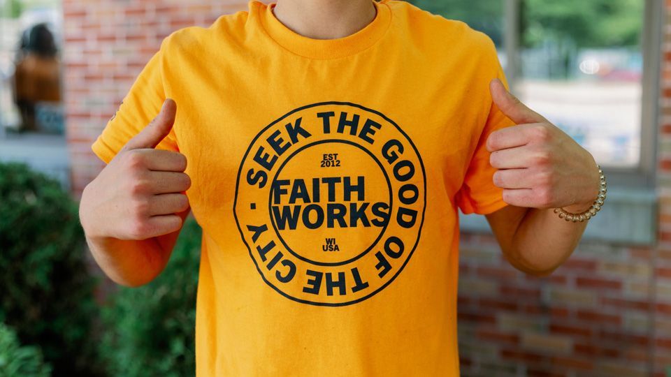Person wearing a yellow t-shirt with the words