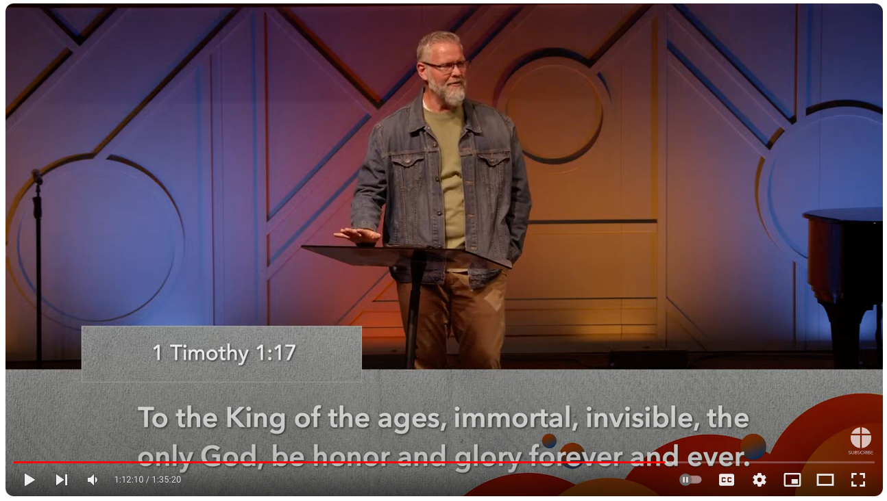 Man speaking at a podium; text from 1 Timothy 1:17: “To the King of the ages…be honor and glory forever.”