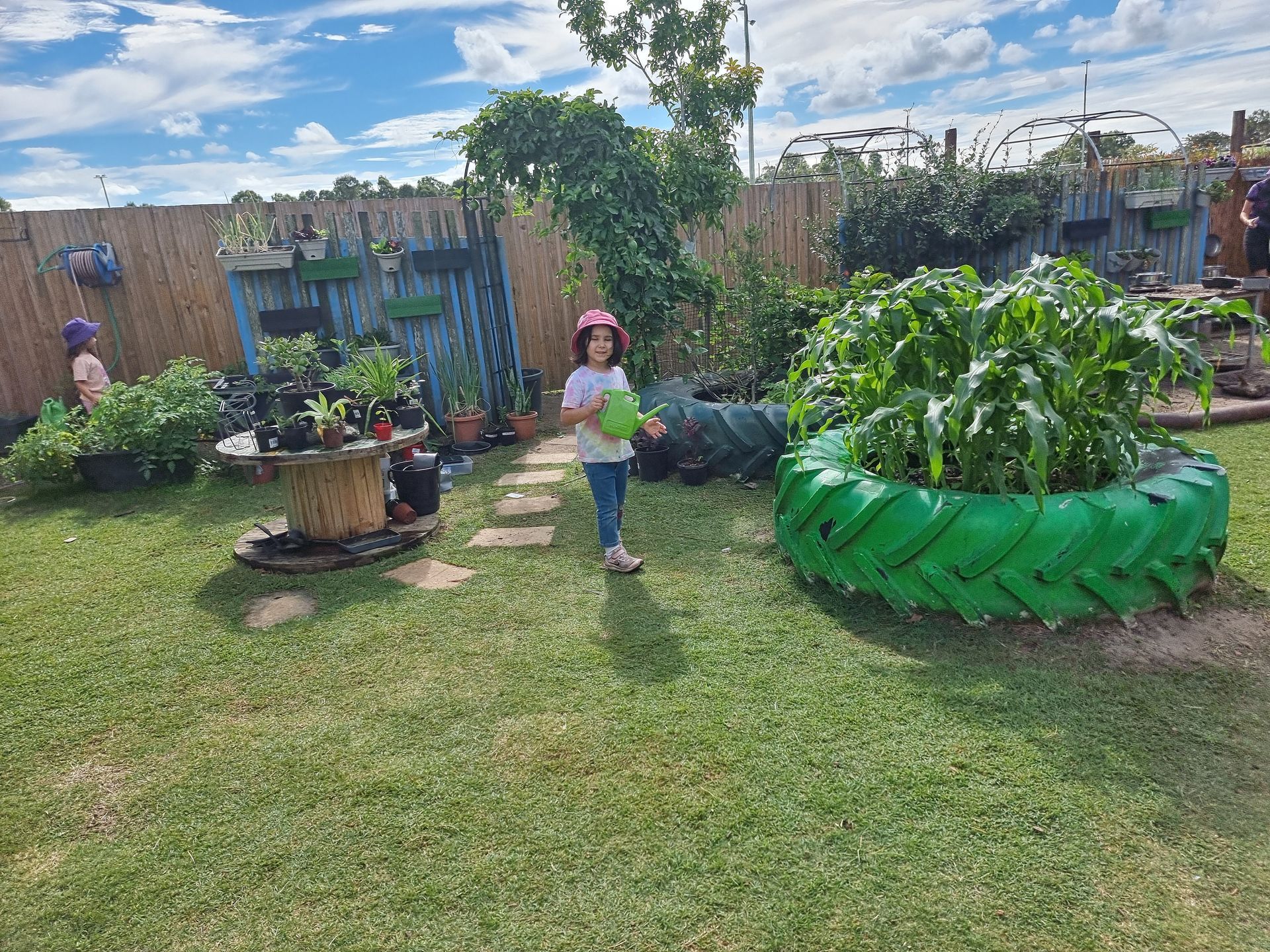 A Group Of Children Are Sitting At A Table Painting With Green Paint – Bundaberg North, QLD - Cradle to Crayons Education & Care