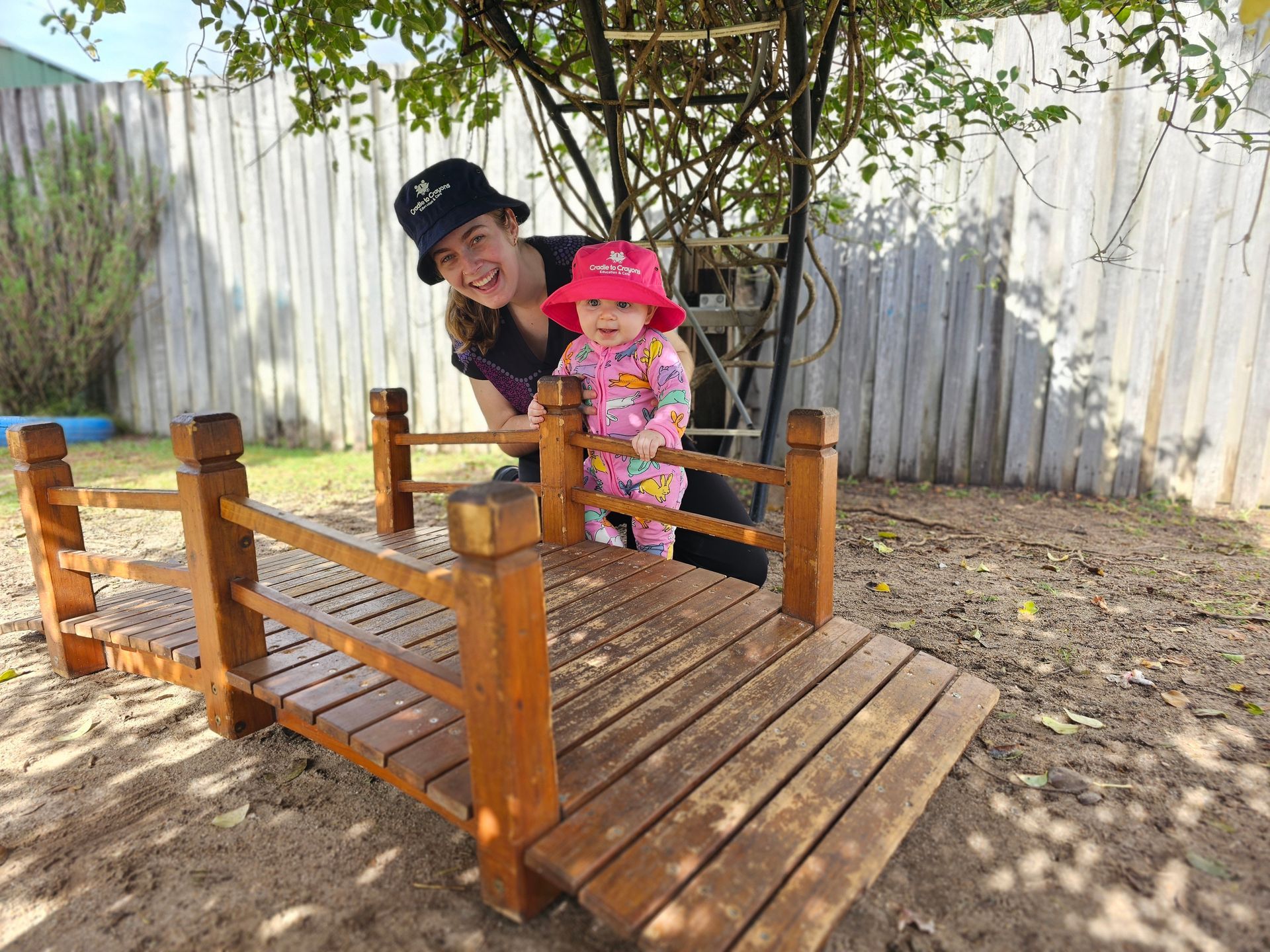 Two Young Boys Are Sitting On A Bench With Their Arms In The Air – Bundaberg North, QLD - Cradle to Crayons Education & Care