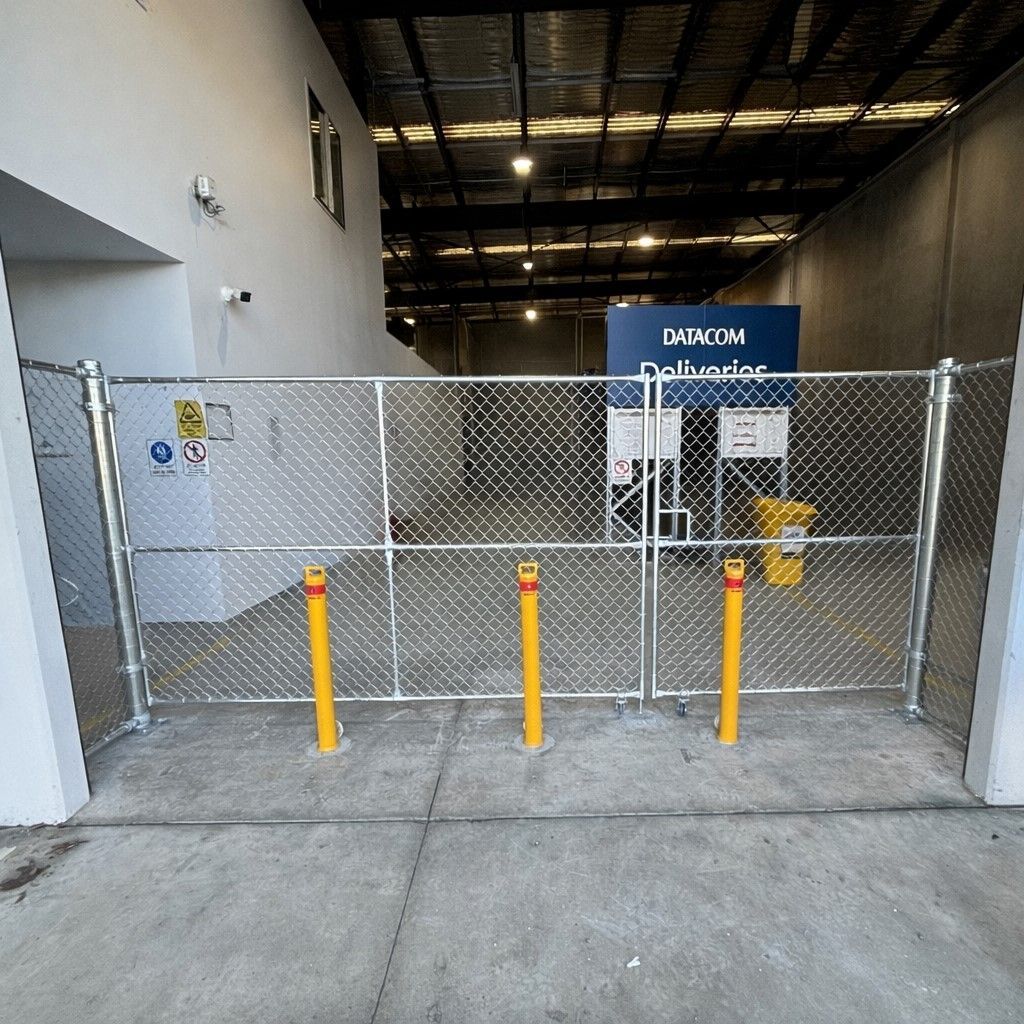 Steel security bollards installed infront of chain mesh fencing installed by Hills Fencing