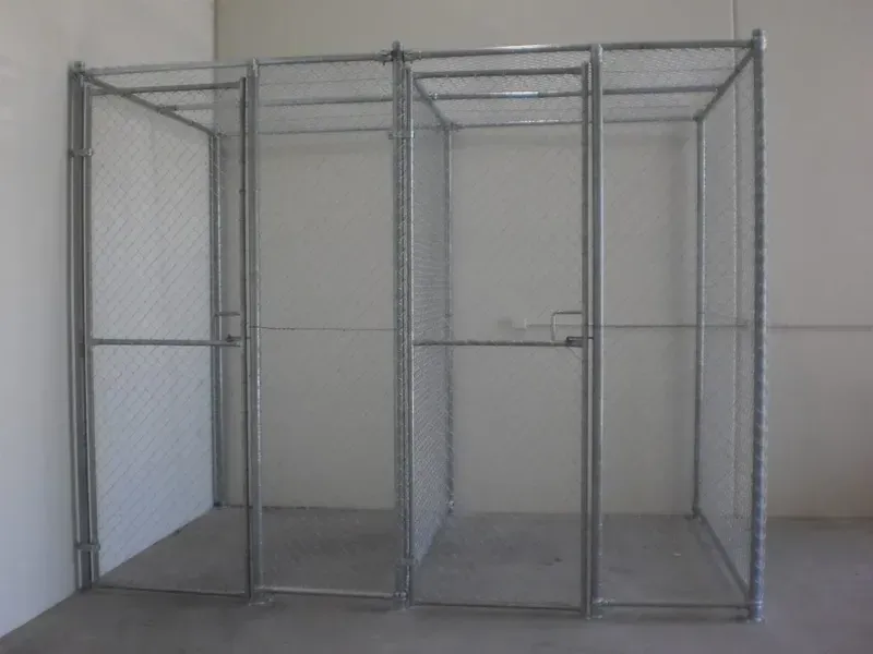A modular storage unit made of metal chain-link fencing, featuring two separate compartments with gated doors.