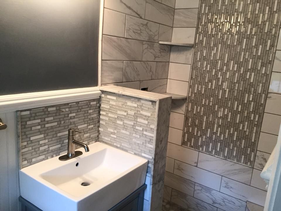 Modern bathroom with a square sink, decorative tile backsplash, and gray walls.