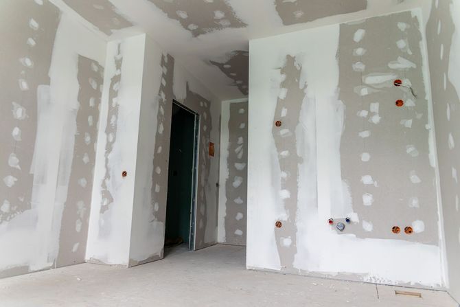 Interior view of a residential construction site featuring metal wall studs, framing, and unfinished floor passages.