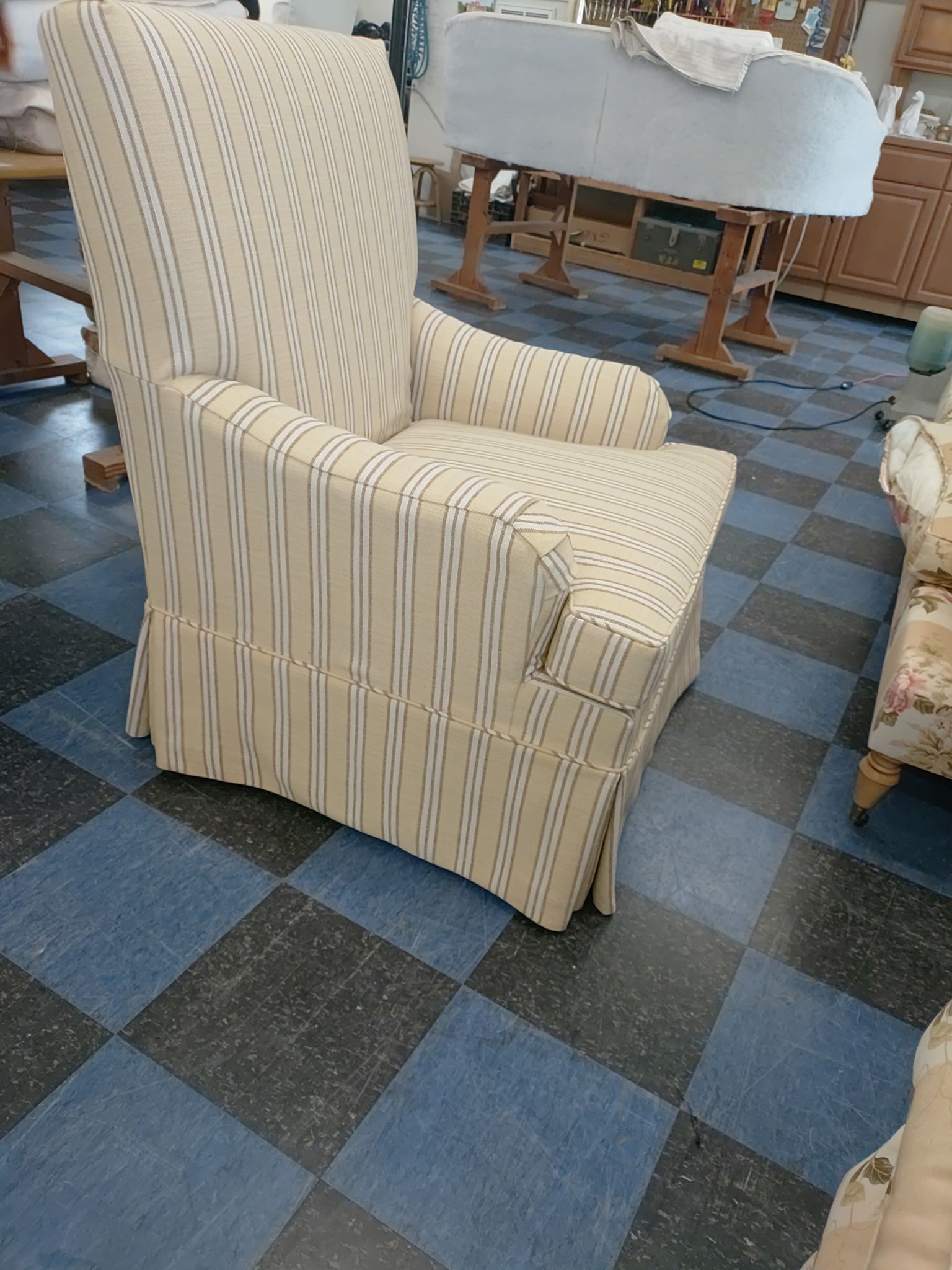 Striped armchair on a blue checkered carpet in a furniture showroom