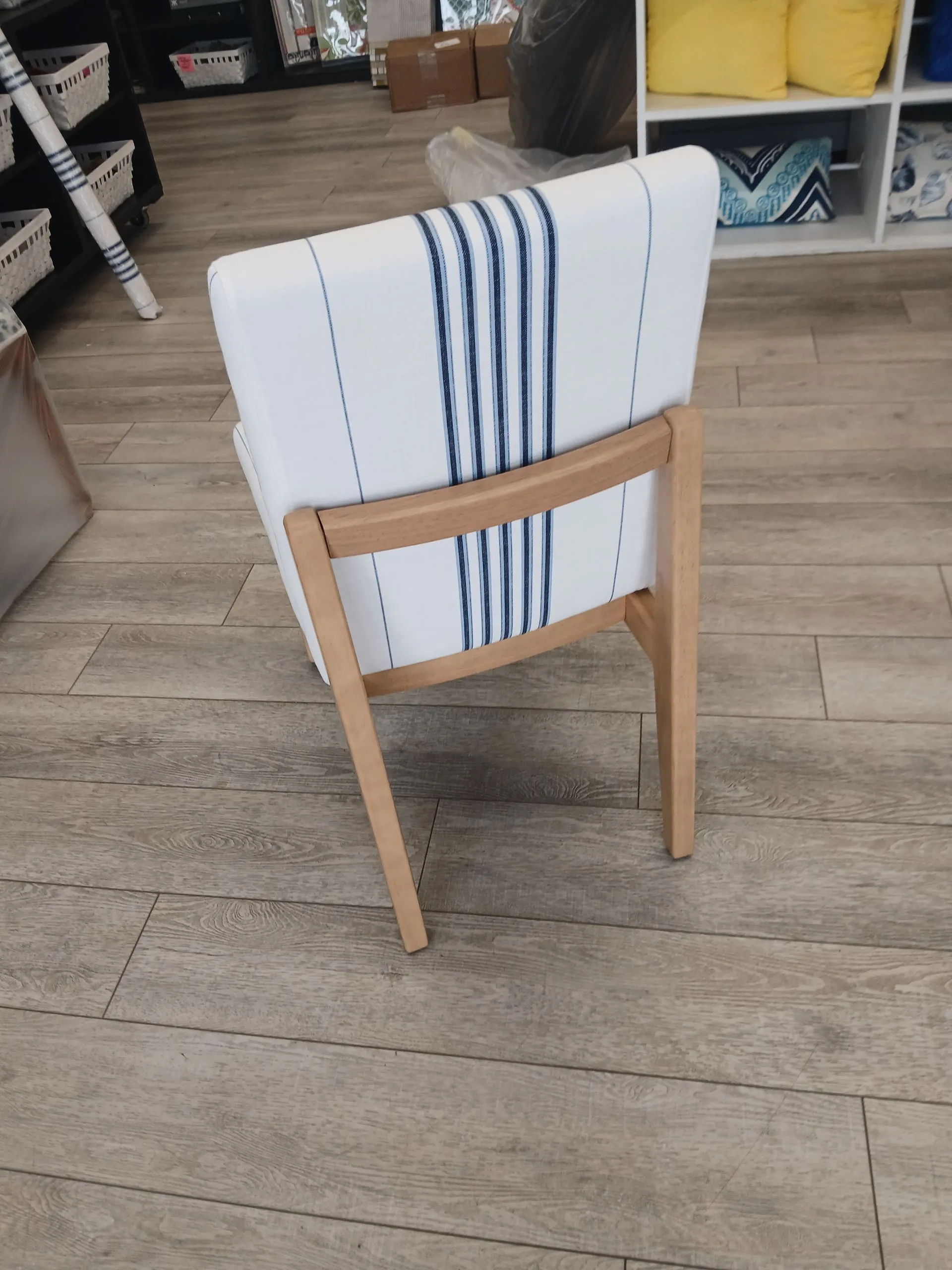 White chair with a striped towel draped over the back in a store or workshop setting