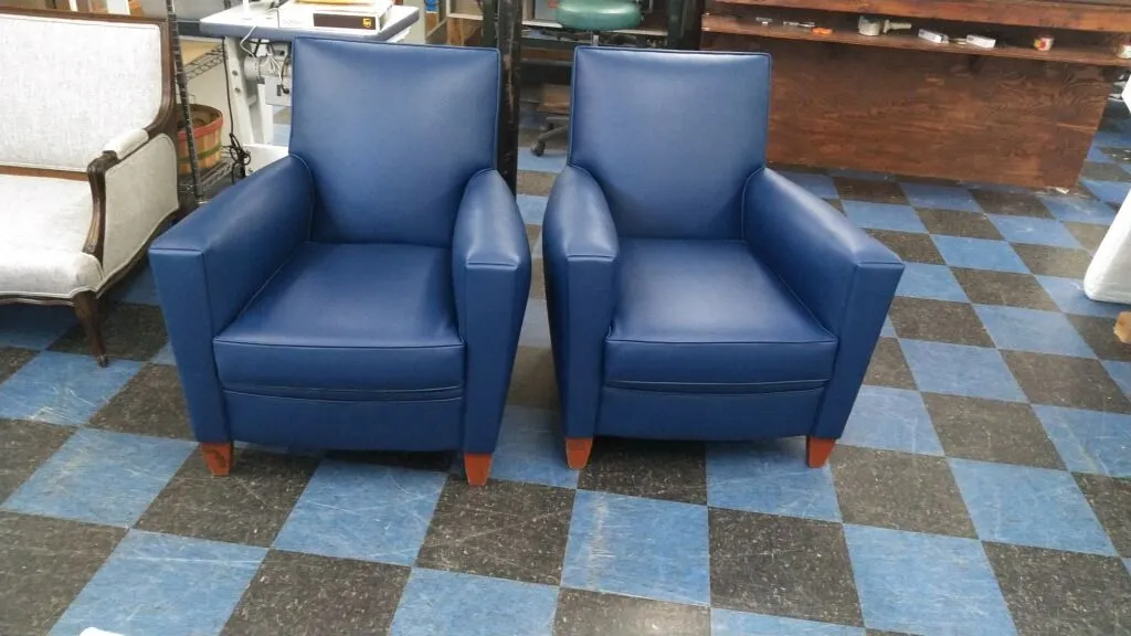 Two blue armchairs on a blue-and-brown checkered floor in a room