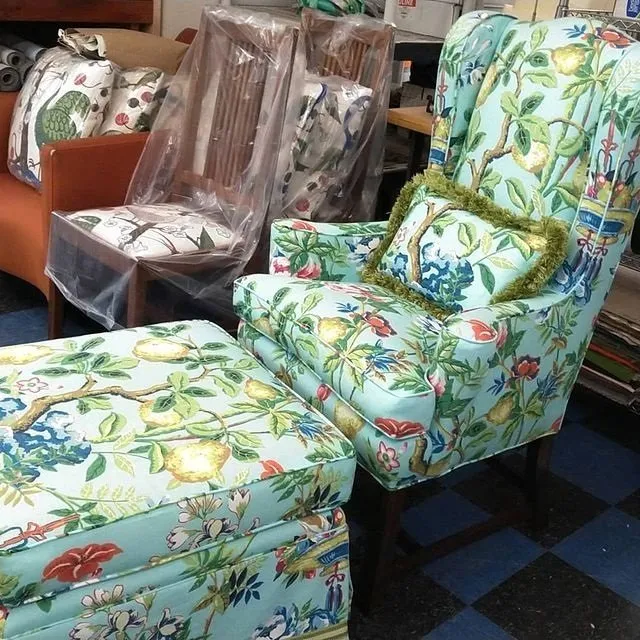Colorful tropical-print upholstered chair and matching ottoman in a furniture showroom