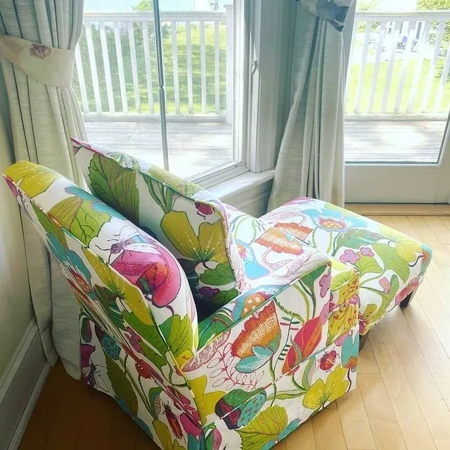 Colorful floral-patterned armchair by a sunlit window in a bright room