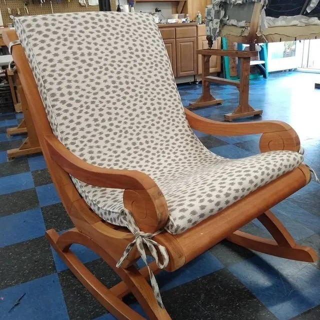 Wooden rocking chair with cream patterned cushion in a showroom or furniture store