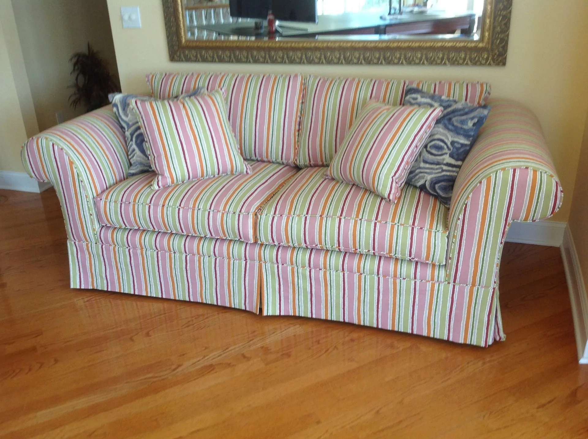 Striped upholstered sofa with matching pillows in a living room on hardwood floor