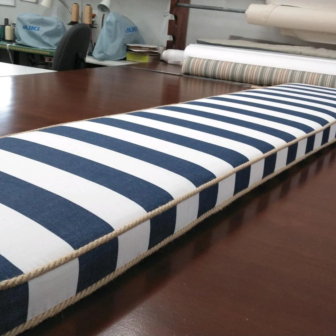 Blue-and-white striped cushion on a wooden table in a workshop