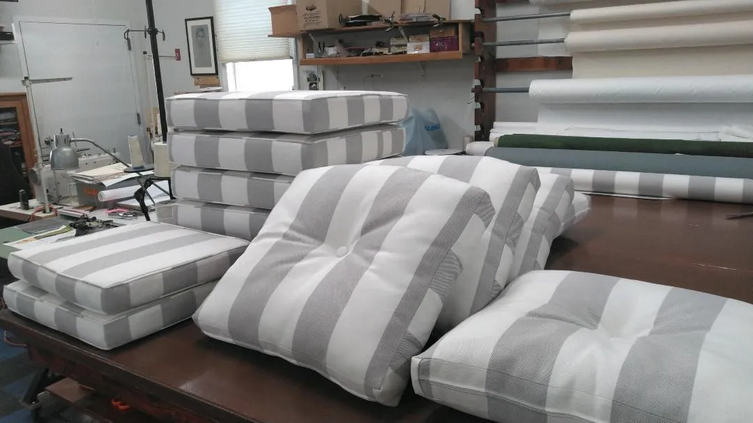 Stacks of gray-and-white striped wrapped packages on a worktable in a workshop-like room