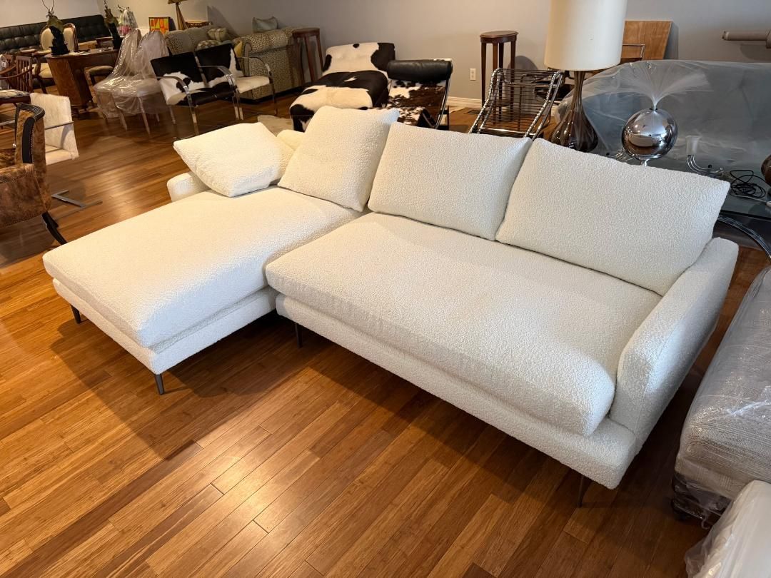 White sectional sofa with chaise in a furniture showroom on a wood floor