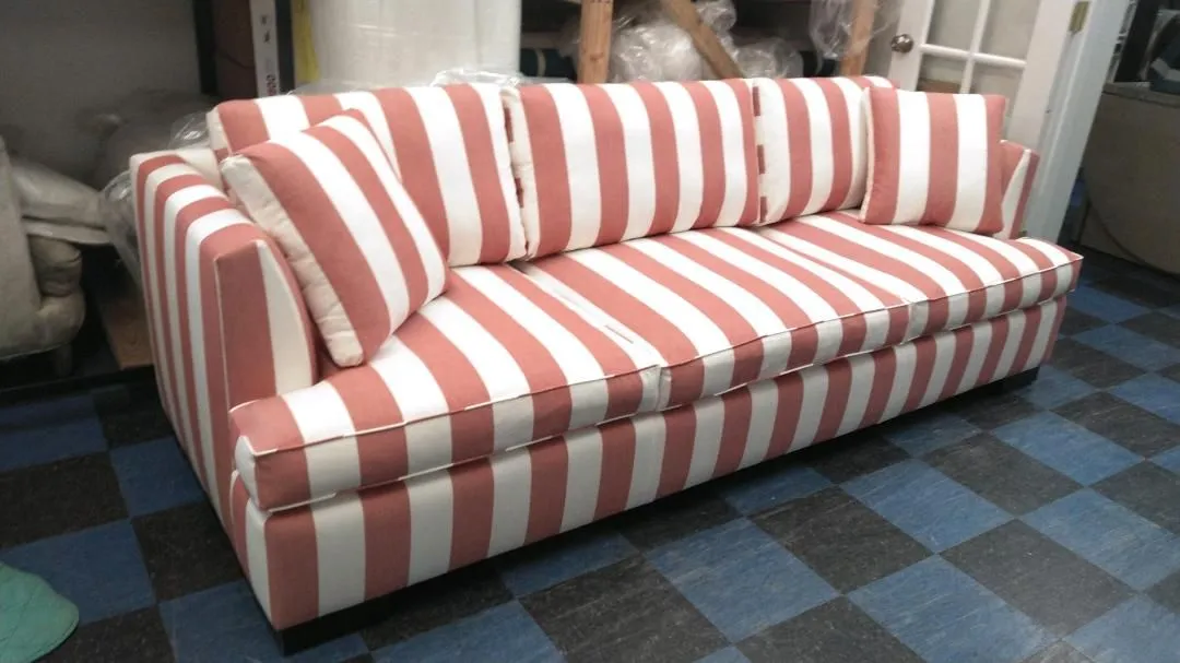 Striped red-and-white sofa on a blue checkered carpet in a living room.