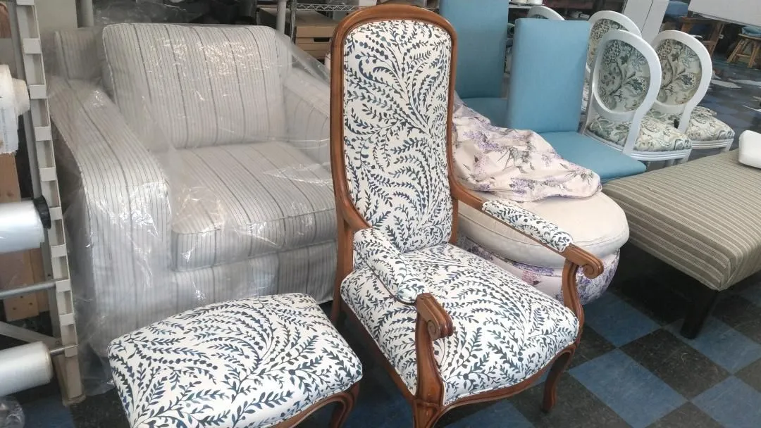 Display of assorted upholstered chairs and sofas in a furniture store, including patterned and wooden-framed seating.
