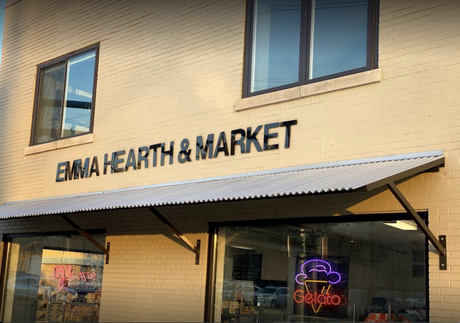 The front of emma hearth & market with a white awning