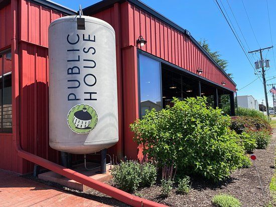 A red building with a white sign that says public house