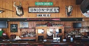A bar with a deer head on the wall and a sign that says union pier.