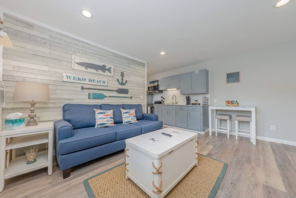 A living room with a blue couch and a white coffee table.