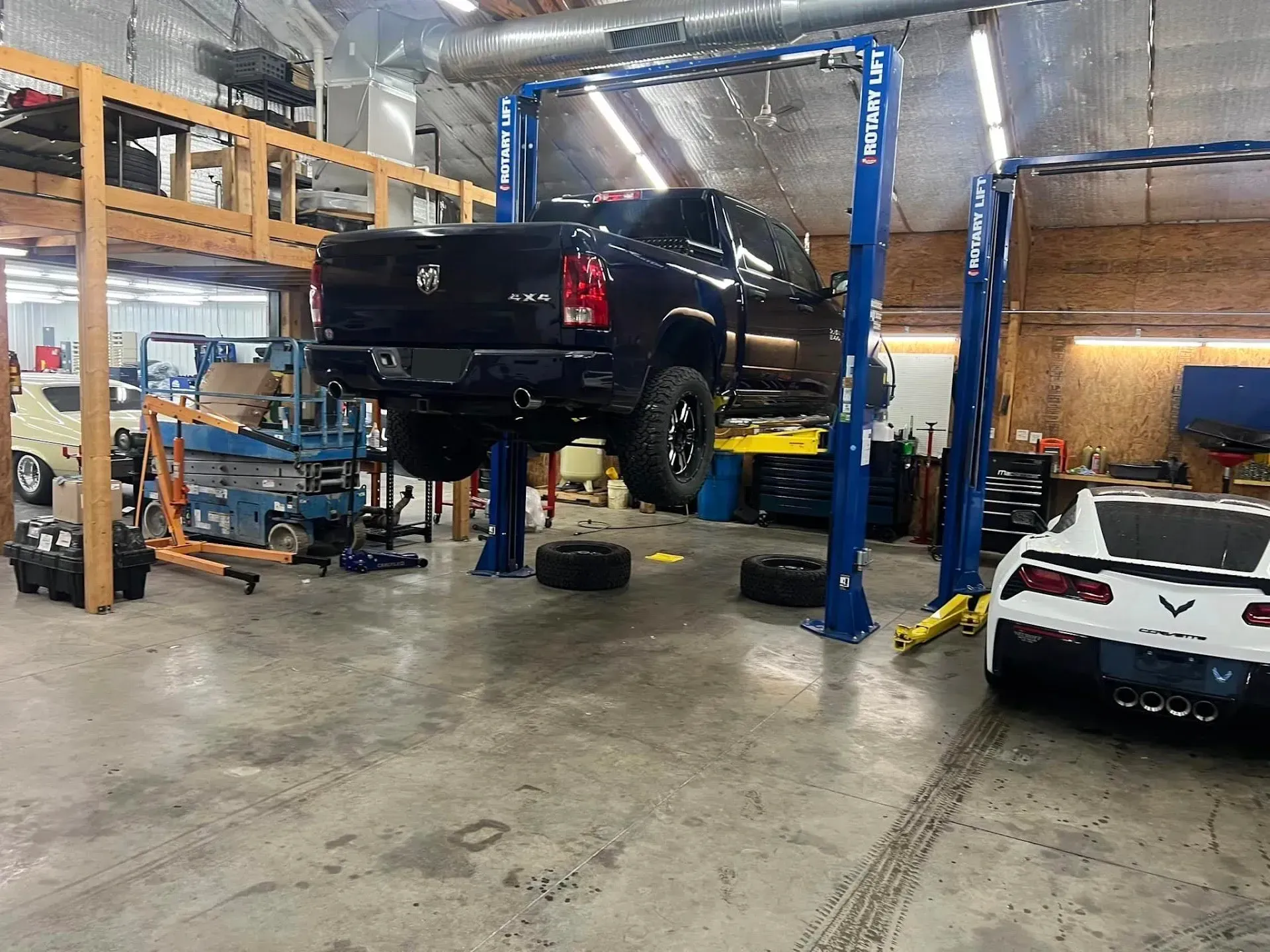 A Dark Pickup Rruck on a Lift in a Garage | Auto Care Center