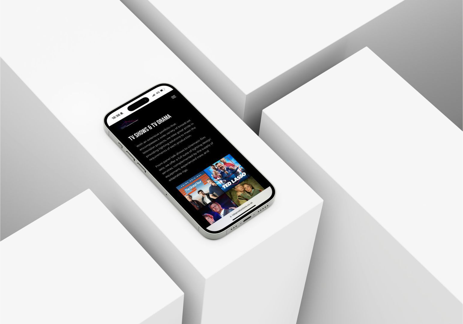 A smartphone displays a social media feed with text and photos, resting on a white geometric platform.