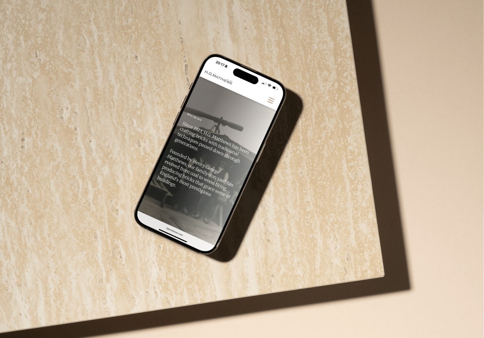 A smartphone displaying a screen with text rests at an angle on a light, textured surface.
