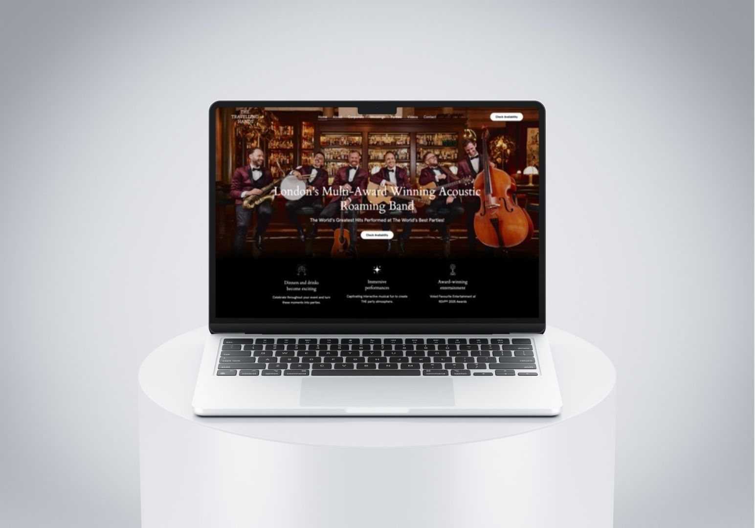A laptop sits on a white cylindrical pedestal, displaying a website featuring a jazz band on its screen.