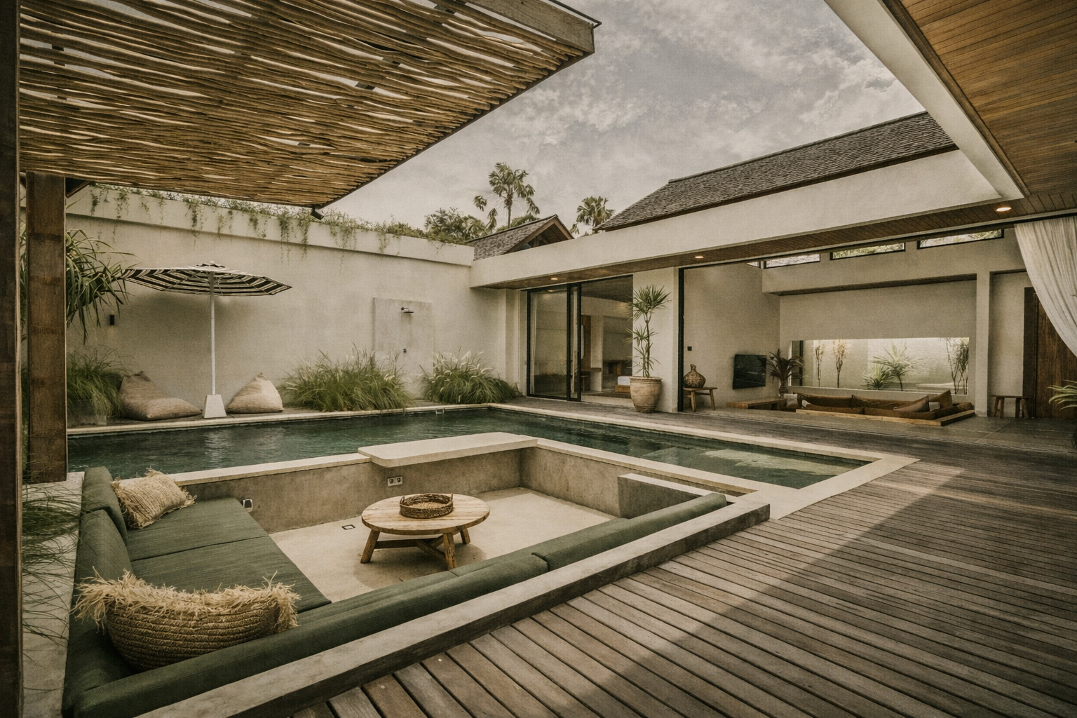 Outdoor living area with pool, sunken seating, and open-air structure.