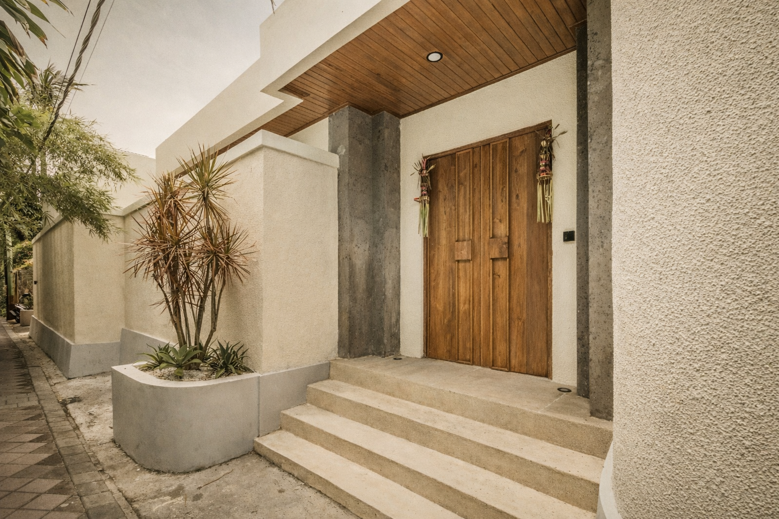 Wooden door and steps leading to a modern building entrance. Neutral tones with a concrete facade.