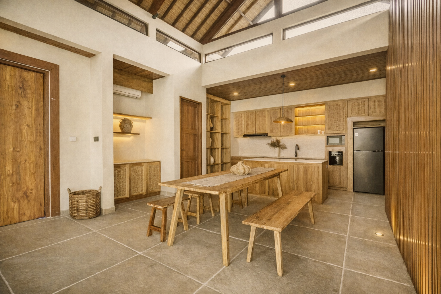 Open-plan kitchen and dining area with wooden furniture and fixtures. Natural light floods the space.