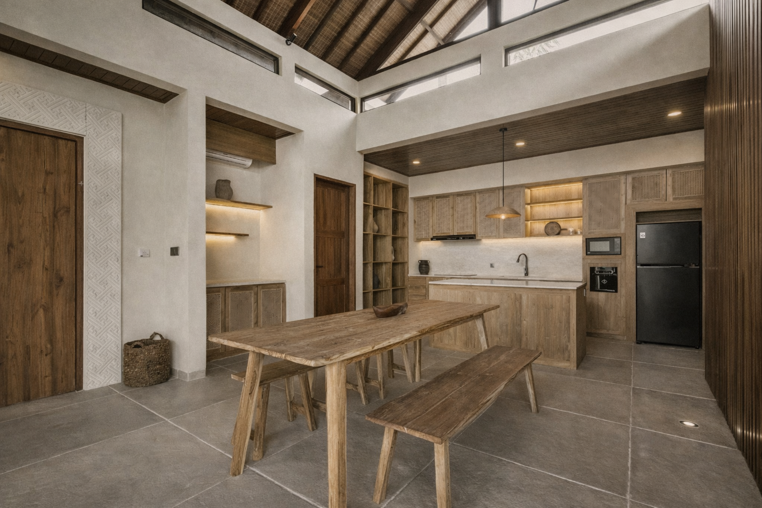 Open-concept kitchen and dining area with wooden furniture, light-colored walls, and a black refrigerator.