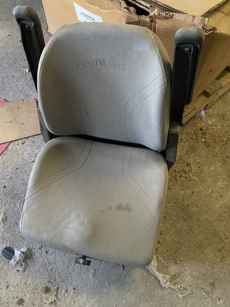 A chair is sitting on the ground next to a cardboard box.