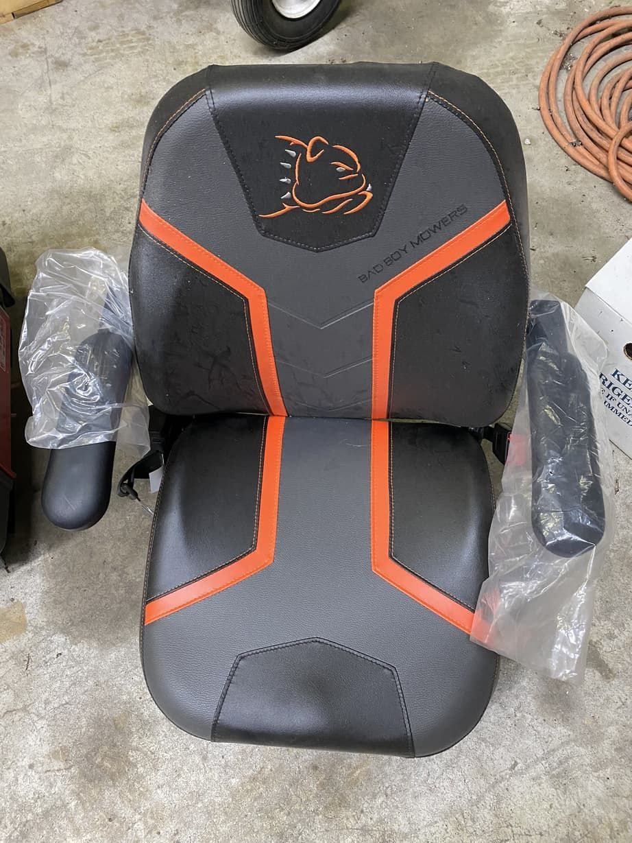 A black and orange chair is sitting on a concrete floor.