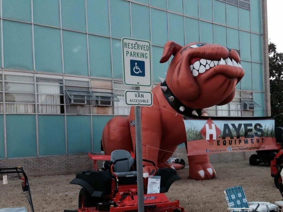 An inflatable bulldog is in front of a hayes equipment sign