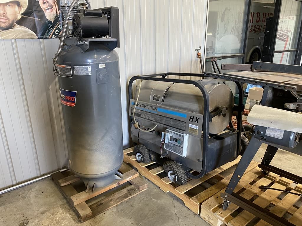 A generator is sitting on a wooden pallet next to a air compressor.