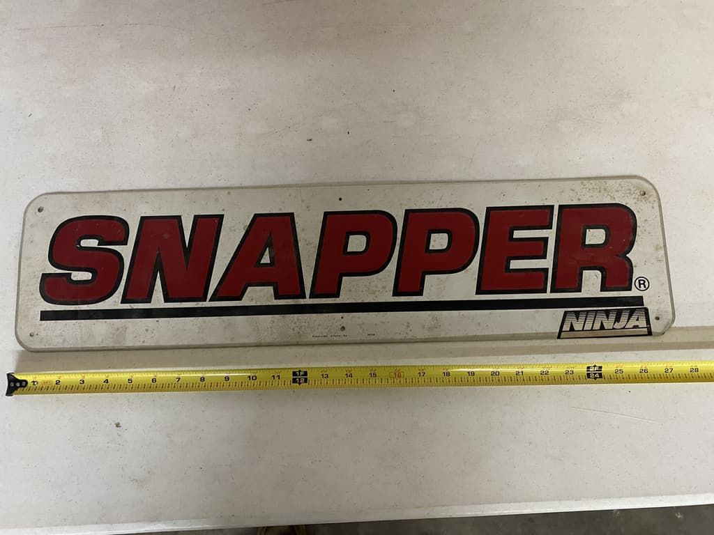 A sign that says snapper on it next to a tape measure
