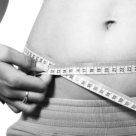 Measuring tape wrapped around a waist to check body size