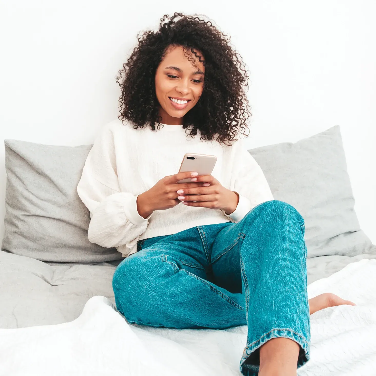 Female reality TV star on her phone sat in her bed