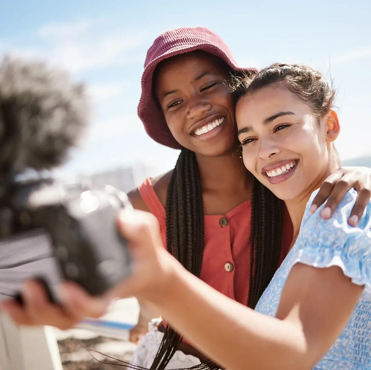 Two female social media influencers filming a video together