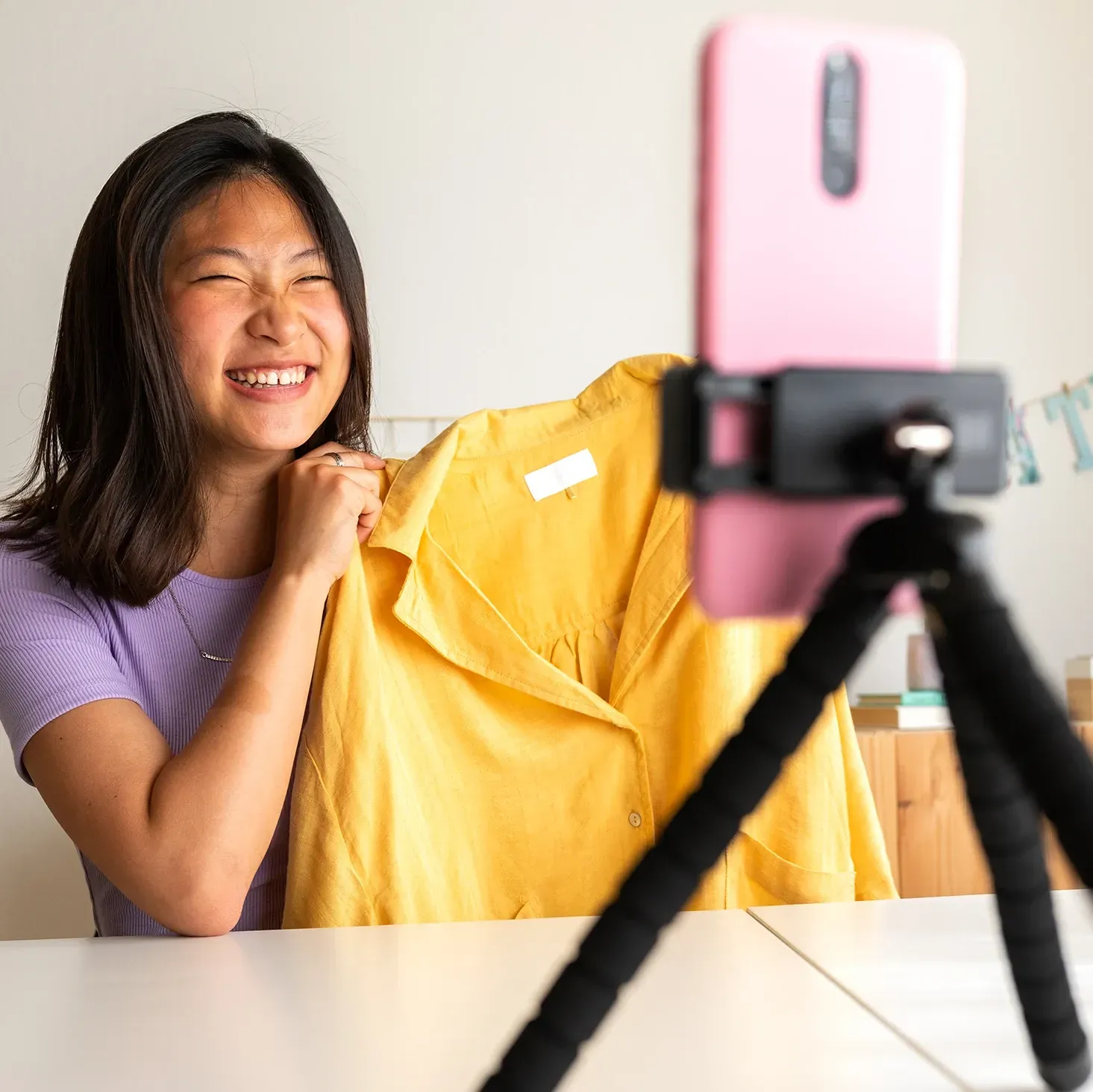 Fashion influencer recording a video in her home using a tripod