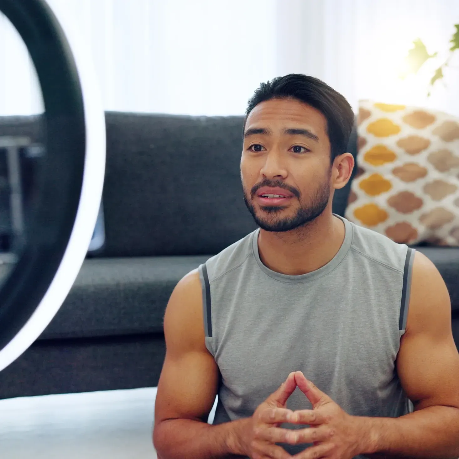 Young, fitness influencer recording a video in his living room