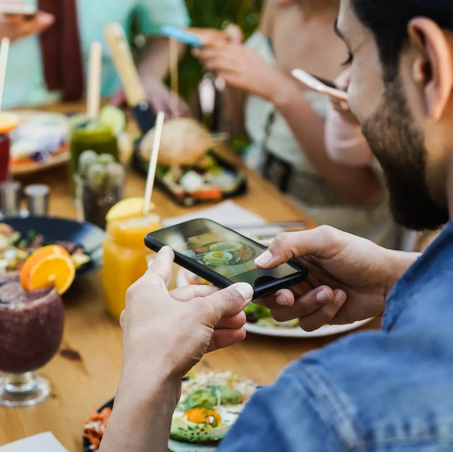 Food influencer taking a photo of his lunch in a cafe