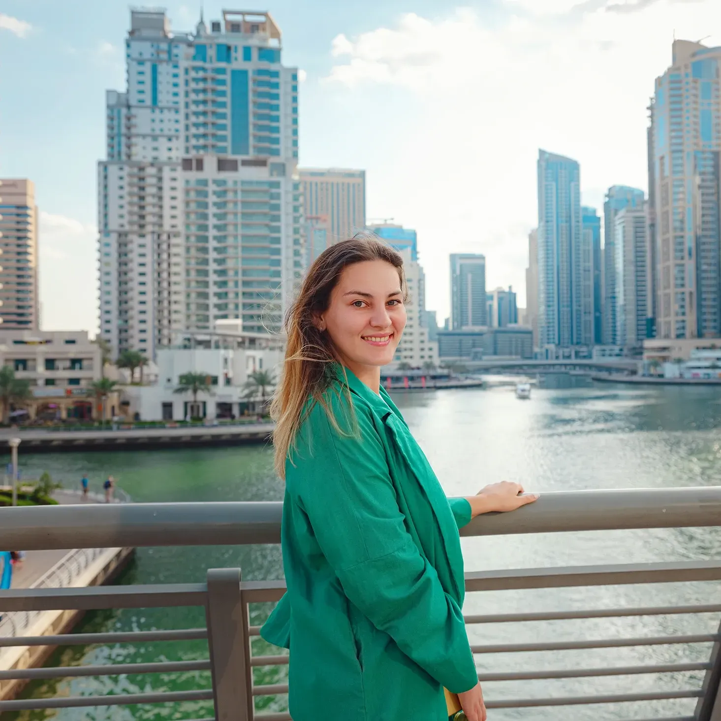 Female social media influencer posing for a photo by the marina in Dubai