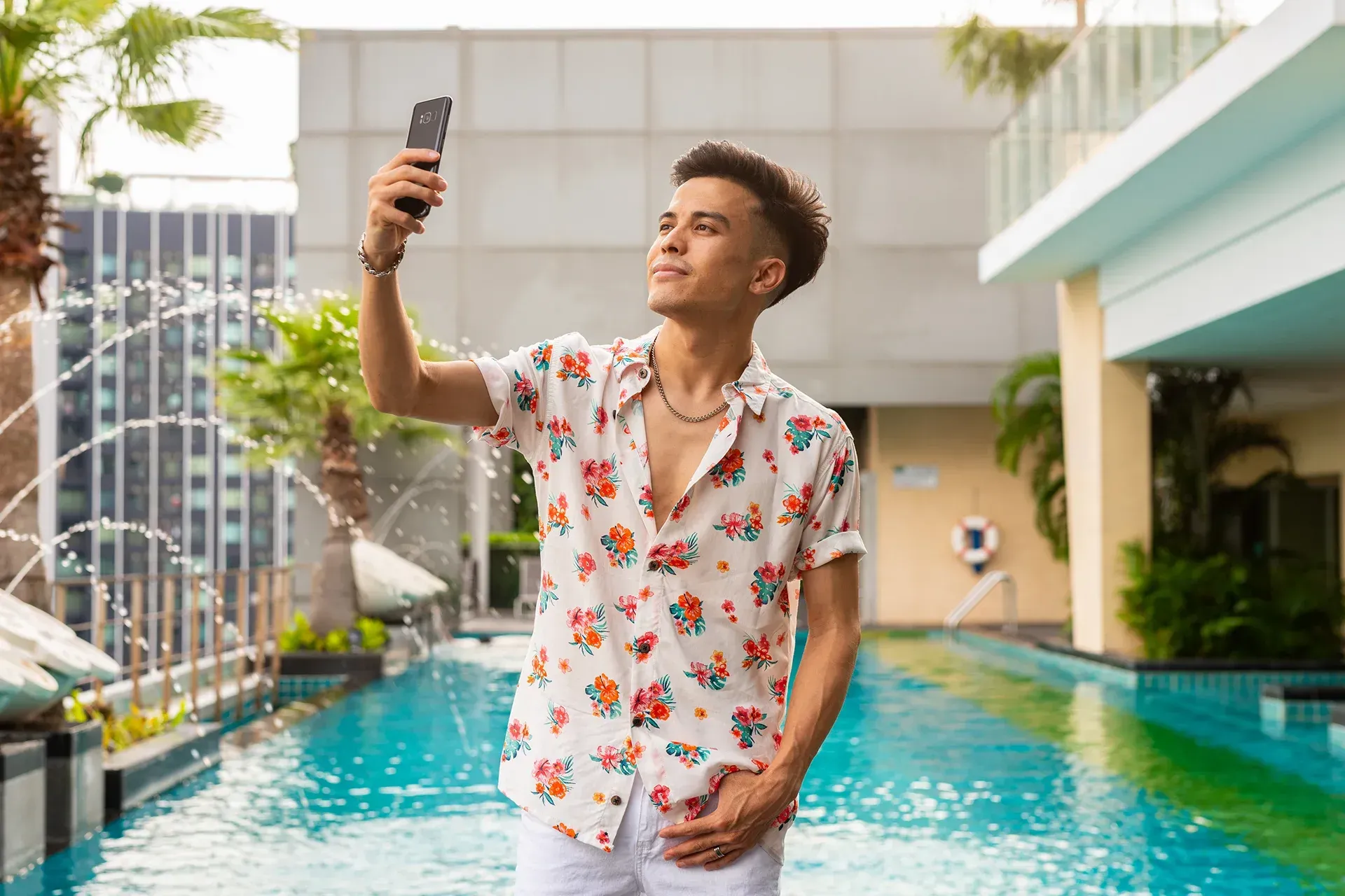 Male creator taking a selfie in front of a pool