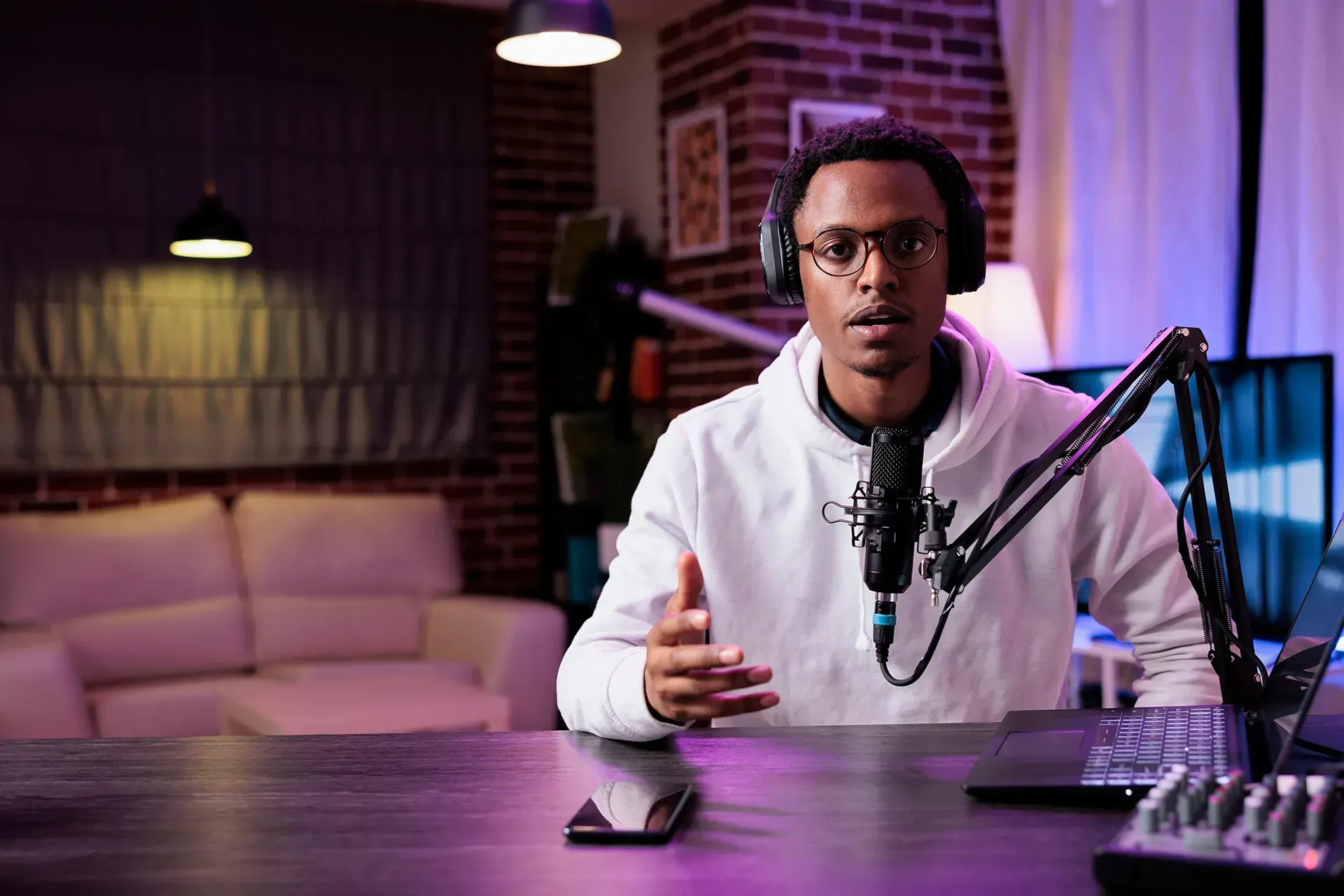 content creator wearing headphones and speaking into a microphone in a home studio