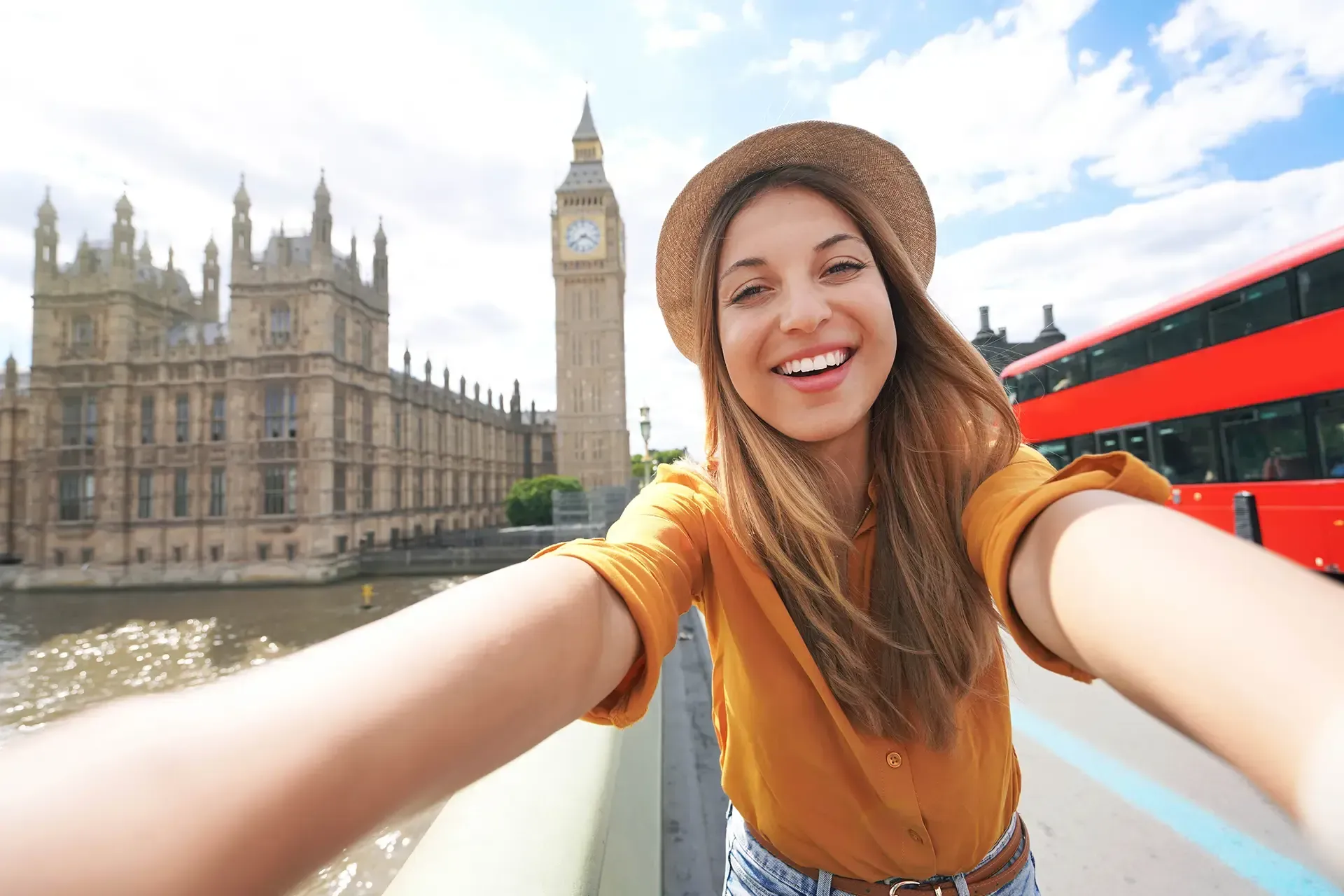 UK YouTuber taking a selfie in London with Big Ben and a red bus, showing how creators are taxed