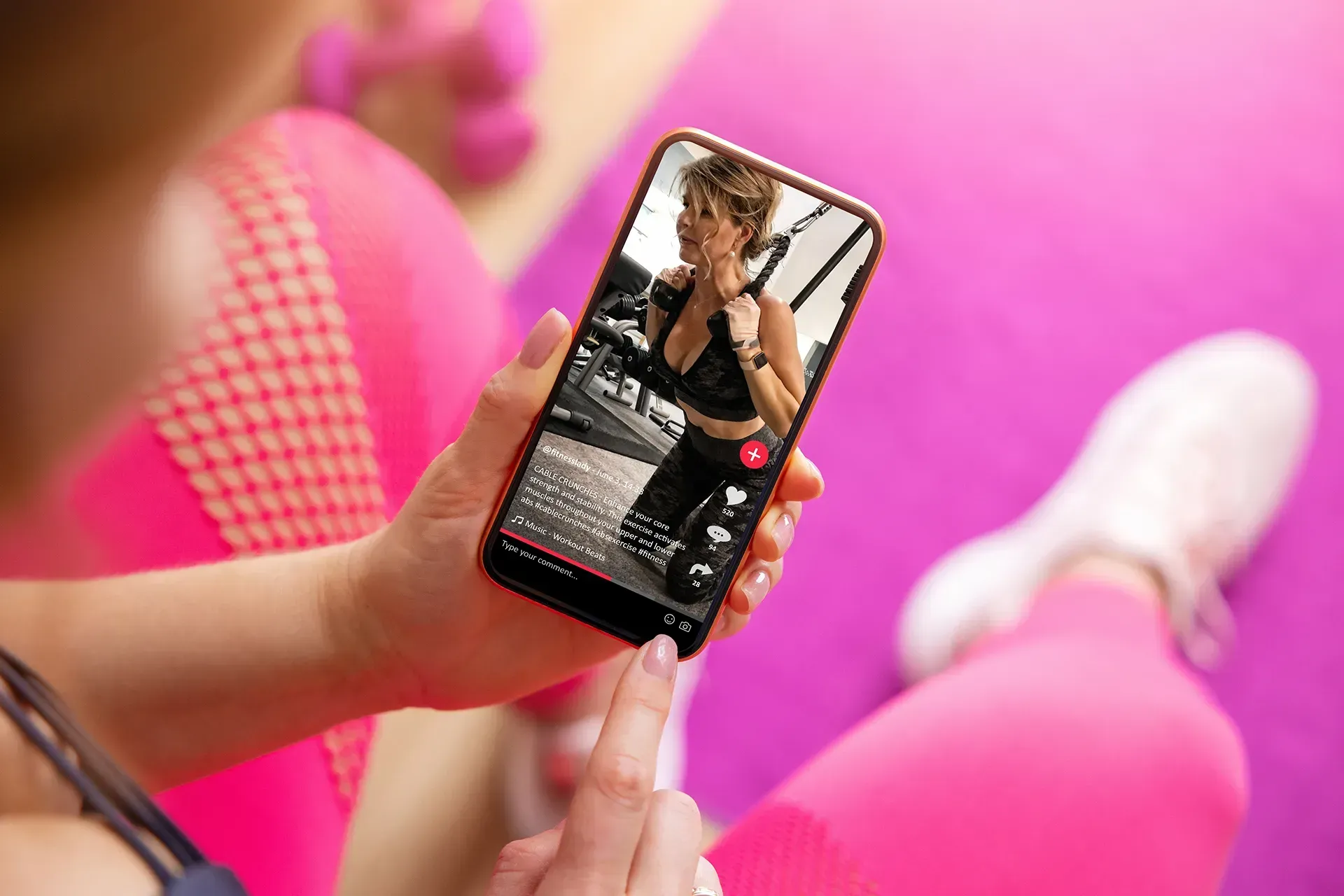 A woman watching a reel of a female fitness creator exercising in the gym