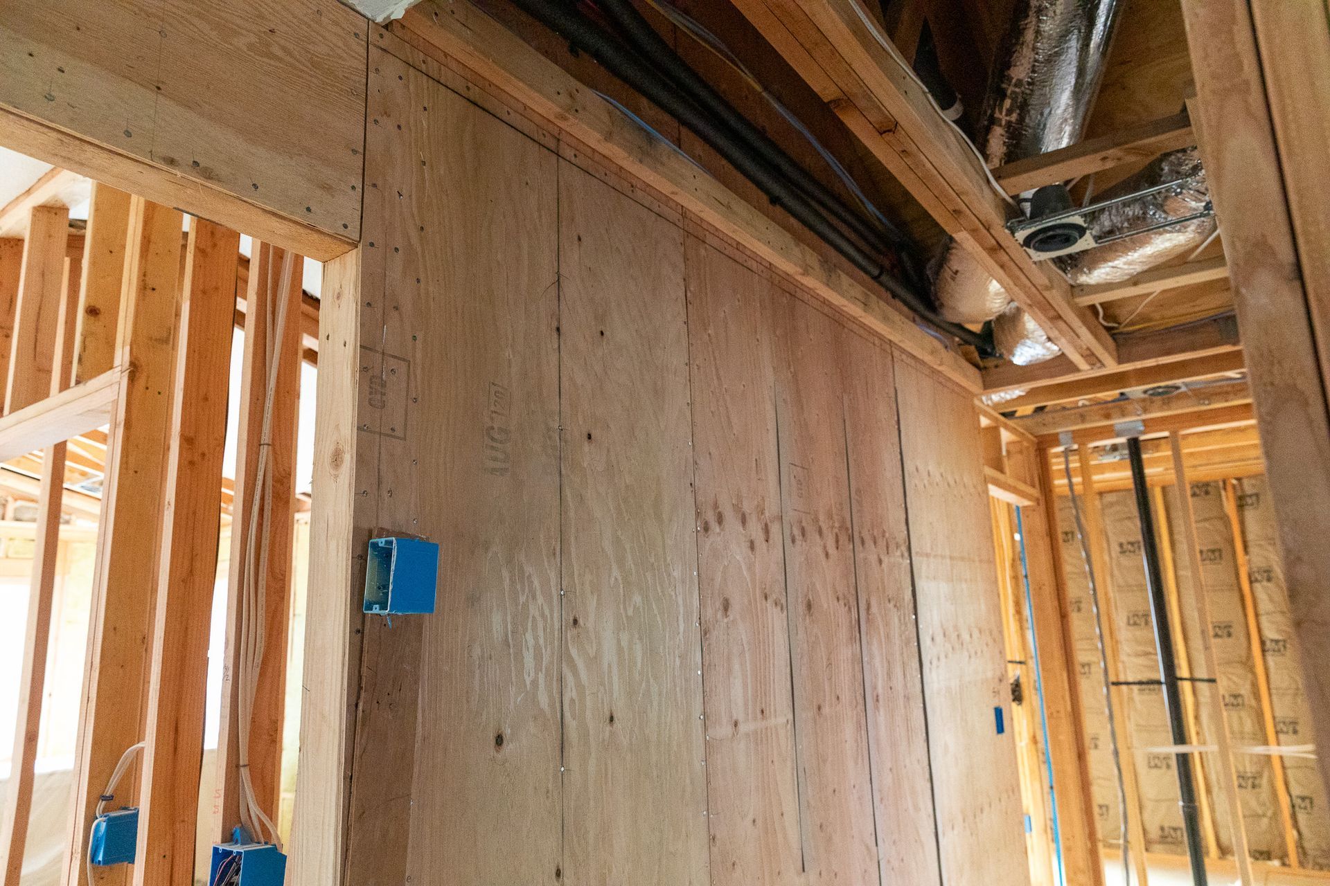 A room in a house under construction with a wooden wall and ceiling.